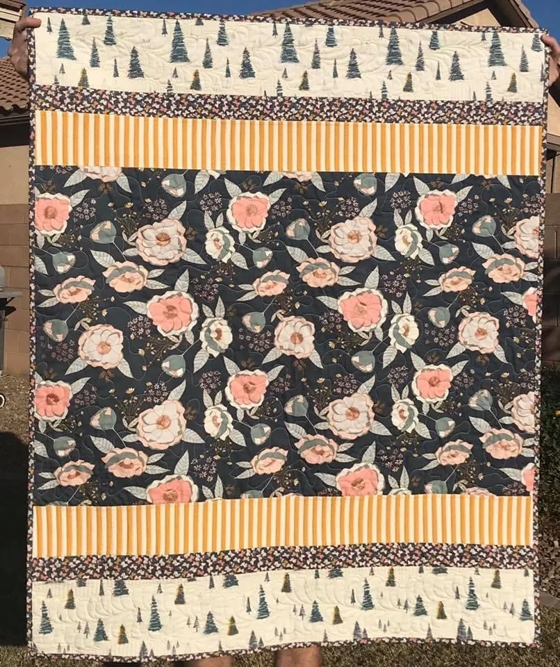 A floral quilt with peonies, trees and mustard stripes