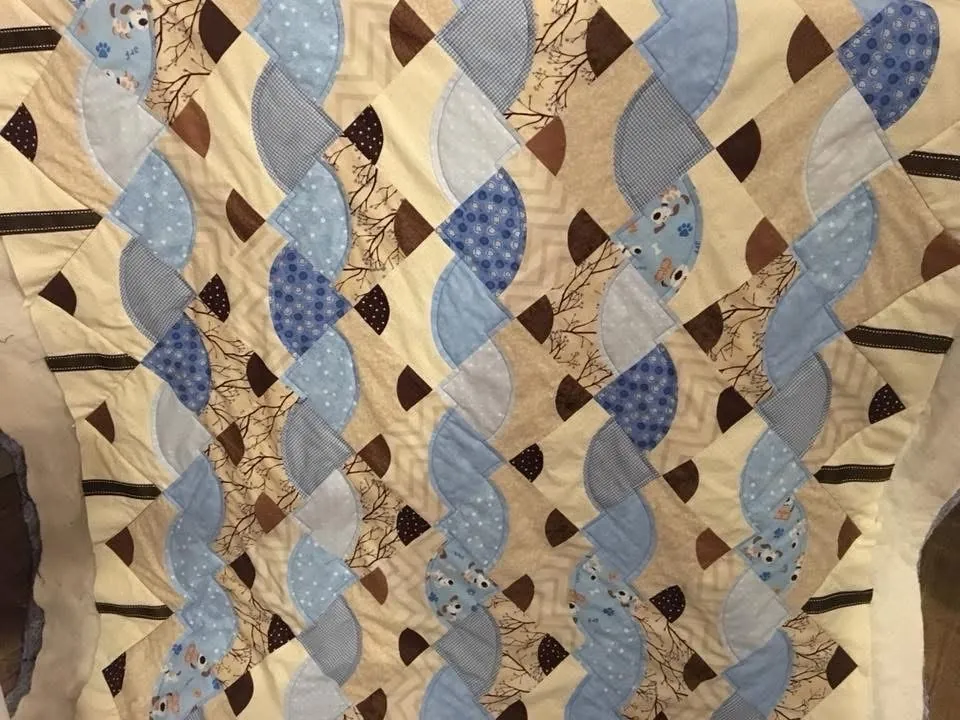 A custom quilt with curved blue and brown blocks